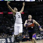 San Antonio Spurs' Boris Diaw (33), of France, leaps for a pass as Phoenix Suns' Marcin Gortat (4), of Poland, moves in to defend during the first half of an NBA basketball game, Wednesday, Feb. 27, 2013, in San Antonio. (AP Photo/Eric Gay)