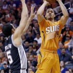 Phoenix Suns' Gerald Green (14) gets off a shot over the defense of San Antonio Spurs' Cory Joseph (5) during the first half of an NBA basketball game, Friday, Feb. 21, 2014, in Phoenix. (AP Photo/Ross D. Franklin)