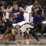 Milwaukee Bucks' Brandon Knight dives for a loose ball in front of Phoenix Suns' Goran Dragic (1) during the first half of an NBA basketball game Wednesday, Jan. 29, 2014, in Milwaukee. (AP Photo/Jeffrey Phelps)