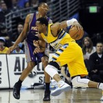 Denver Nuggets guard Andre Iguodala, right, tries to drive past Phoenix Suns forward Wesley Johnson, left, in the first quarter of an NBA basketball game on Wednesday, April 17, 2013, in Denver. (AP Photo/Chris Schneider)