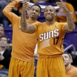 Phoenix Suns' P.J. Tucker (17) and Gerald Green cheer on their teammates during the second half of an NBA basketball game against the San Antonio Spurs, Friday, Feb. 21, 2014, in Phoenix. The Suns defeated the Spurs 106-85. (AP Photo/Ross D. Franklin)