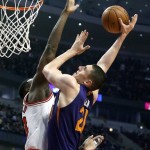 Phoenix Suns center Alex Len, right, shoots over Chicago Bulls center Nazr Mohammed during the first half of an NBA basketball game, Tuesday, Jan. 7, 2014, in Chicago. (AP Photo/Charles Rex Arbogast)