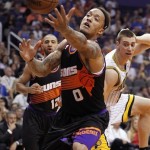 Phoenix Suns forward Michael Beasley, center, struggles to gain control of a ball before it lands out of bounds as Suns guard Kendall Marshall, left rear, and Indiana Pacers forward Tyler Hansbrough, right rear, look on during the first half of an NBA basketball game, Saturday, March 30, 21013, in Phoenix. (AP Photo/Paul Connors)