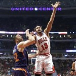 Chicago Bulls center Joakim Noah (13) shoots over Phoenix Suns center Miles Plumlee during the first half of an NBA basketball game, Tuesday, Jan. 7, 2014, in Chicago. (AP Photo/Charles Rex Arbogast)