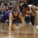 Milwaukee Bucks' Brandon Knight, right, and Phoenix Suns' Goran Dragic dive for a loose ball during the second half of an NBA basketball game Wednesday, Jan. 29, 2014, in Milwaukee. (AP Photo/Jeffrey Phelps)