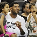 San Antonio Spurs' Tim Duncan, center, sits on the Spurs bench with his daughter, Sydney, left, and son, Draven, before an NBA preseason basketball game against the Phoenix Suns, Sunday, Oct. 13, 2013, in San Antonio. (AP Photo/Darren Abate)