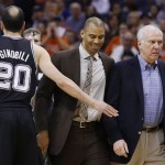 San Antonio Spurs coach Gregg Popovich, right, is escorted back to the bench by assistant coach Ime Udoka, second from right, as they walk past Manu Ginobili (20), of Argentina, who holds out his hand, after Popovich was called for a technical foul during the first half of an NBA basketball game against the Phoenix Suns, Friday, Feb. 21, 2014, in Phoenix. (AP Photo/Ross D. Franklin)