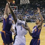 Orlando Magic's Victor Oladipo (5) gets between Phoenix Suns' Miles Plumlee, left, and Gerald Green (14) for a shot during the first half of an NBA basketball game in Orlando, Fla., Sunday, Nov. 24, 2013. (AP Photo/John Raoux)