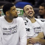 San Antonio Spurs' Manu Ginobili, right, of Argentina, laughs with teammate Tim Duncan on the bench during the second half of an NBA preseason basketball game against the Phoenix Suns, Sunday, Oct. 13, 2013, in San Antonio. Phoenix won 106-99. (AP Photo/Darren Abate)