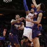 New York Knicks' Carmelo Anthony (7) drives past Phoenix Suns' Gerald Green (14) and Channing Frye (8) during the first half of an NBA basketball game, Monday, Jan. 13, 2014, in New York. (AP Photo/Frank Franklin II)