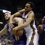 Milwaukee Bucks' John Henson battles for a loose ball with Phoenix Suns' Miles Plumlee and Eric Bledsoe (2) during the first half of an NBA basketball game Tuesday, Jan. 6, 2015, in Milwaukee. (AP Photo/Morry Gash)