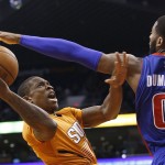 Phoenix Suns' Eric Bledsoe, left, gets fouled as he goes up for a shot against Detroit Pistons' Andre Drummond (0) during the second half of an NBA basketball game Friday, Dec. 12, 2014, in Phoenix. The Pistons defeated the Suns 105-103. (AP Photo/Ross D. Franklin)
