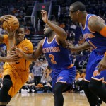 New York Knicks' Raymond Felton (2) fouls Phoenix Suns' Eric Bledsoe, left, as Knicks' Amare Stoudemire (1) watches during the second half of an NBA basketball game, Friday, March 28, 2014, in Phoenix. The Suns won 112-88. (AP Photo/Matt York)