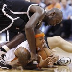 Phoenix Suns' Isaiah Thomas, bottom, tries to call a timeout while keeping the ball away from Brooklyn Nets' Kevin Garnett during the second half of an NBA basketball game Wednesday, Nov. 12, 2014, in Phoenix. The Suns defeated the Nets 112-104. (AP Photo/Ross D. Franklin)