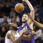 Phoenix Suns' Miles Plumlee, right, knocks the ball from Charlotte Hornets' Al Jefferson during the second half of an NBA basketball game in Charlotte, N.C., Wednesday, Dec. 17, 2014. The Suns won 111-106. (AP Photo/Chuck Burton)