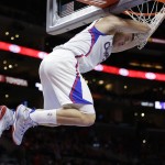 Los Angeles Clippers' Blake Griffin clings to the rim after making a dunk during the first half of an NBA basketball game against the Phoenix Suns, Monday, Dec. 8, 2014, in Los Angeles. (AP Photo/Jae C. Hong)
