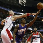 Phoenix Suns guard Eric Bledsoe (2) can't get a shot over Washington Wizards center Marcin Gortat (4), from Poland, with guard John Wall (2) at right, in the first half of an NBA basketball game, Sunday, Dec. 21, 2014, in Washington. (AP Photo/Alex Brandon)