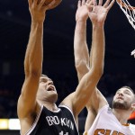 Brooklyn Nets' Brook Lopez (11) goes in for a score against Phoenix Suns' Miles Plumlee (22) during the first half of an NBA basketball game Wednesday, Nov. 12, 2014, in Phoenix. (AP Photo/Ross D. Franklin)