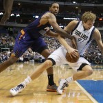Dallas Mavericks' Dirk Nowitzki, right, falls as he is guarded by Phoenix Suns' Channing Frye, left, in the first quarter of an NBA basketball game in Dallas, Saturday, April 12, 2014. (AP Photo/Dallas Morning News, Louis DeLuca)