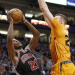 Chicago Bulls' Jimmy Butler (21) bounces off Phoenix Suns' Miles Plumlee as Butler drives to the basket during the first half of an NBA basketball game Friday, Jan. 30, 2015, in Phoenix. (AP Photo/Ross D. Franklin)