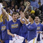 Golden State Warriors' David Lee, front left, and Stephen Curry celebrate a score by the team, during the first half of an NBA basketball game against the Phoenix Suns on Thursday, April 2, 2015, in Oakland, Calif. (AP Photo/Ben Margot)