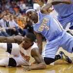 Denver Nuggets' Ty Lawson (3) battles Phoenix Suns' Eric Bledsoe (2) for a loose ball during the first half of an NBA basketball game Wednesday, Nov. 26, 2014, in Phoenix. (AP Photo/Ross D. Franklin)