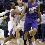 Los Angeles Clippers' Blake Griffin, center, and teammate Chris Paul, left, celebrate a game-winning three-point basket by Griffin behind Phoenix Suns' P.J. Tucker in an NBA basketball game Monday, Dec. 8, 2014, in Los Angeles. The Clippers won 121-120 in overtime. (AP Photo/Jae C. Hong)