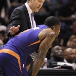 Phoenix Suns head coach Jeff Hornacek, rear, talks to Suns' Eric Bledsoe during the first half of an NBA basketball game against the San Antonio Spurs on Friday, April 11, 2014, in San Antonio. (AP Photo/Darren Abate)
