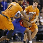 Phoenix Suns' Markieff Morris (11) fouls Detroit Pistons' Jodie Meeks, middle, as Suns' Goran Dragic, right, of Slovenia, defends during the second half of an NBA basketball game Friday, Dec. 12, 2014, in Phoenix. The Pistons defeated the Suns 105-103. (AP Photo/Ross D. Franklin)