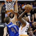 Phoenix Suns' Isaiah Thomas (3) tries to shoot as Dallas Mavericks' Dirk Nowitzki (41), of Germany, defends during the first half of an NBA basketball game Tuesday, Dec. 23, 2014, in Phoenix. (AP Photo/Ross D. Franklin)
