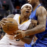 Phoenix Suns' Isaiah Thomas, left, tries to drive past Dallas Mavericks' Greg Smith, right, during the second half of an NBA basketball game Tuesday, Dec. 23, 2014, in Phoenix. The Suns won 124-115. (AP Photo/Ross D. Franklin)
