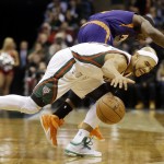 Milwaukee Bucks' Jerryd Bayless and Phoenix Suns' Eric Bledsoe go after a loose ball during the first half of an NBA basketball game Tuesday, Jan. 6, 2015, in Milwaukee. (AP Photo/Morry Gash)