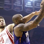 Phoenix Suns' P.J. Tucker, right, is pressured by Houston Rockets' Donatas Motiejunas (20) as he goes for two points in the first half of an NBA basketball game Saturday, Dec. 6, 2014, in Houston. (AP Photo/Pat Sullivan)