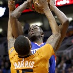 Phoenix Suns' Marcus Morris (15) stops Philadelphia 76ers' Jerami Grant from getting a shot off during the first half of an NBA basketball game Friday, Jan. 2, 2015, in Phoenix. (AP Photo/Ross D. Franklin)
