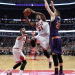 Chicago Bulls guard Jimmy Butler (21) goes in for a lay up past Phoenix Suns center Alex Len (21) as teammate Joakim Noah (13) looks on during the second half of an NBA basketball game in Chicago, on Saturday, Feb. 21, 2015. The Bulls won the game 112-107. (AP Photo/Jeff Haynes)