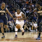 Phoenix Suns guard Eric Bledsoe, center, pushes the ball up court against Indiana Pacers forward David West (21) and Roy Hibbert (55) during the second half of an NBA basketball game, Tuesday, Dec. 2, 2014, in Phoenix. The Suns won 116-99. (AP Photo/Matt York)