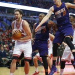 Chicago Bulls forward Pau Gasol (16) grabs a rebound from Phoenix Suns forward P.J. Tucker (17) and center Alex Len (21) during the second half of an NBA basketball game in Chicago, on Saturday, Feb. 21, 2015. The Bulls won the game 112-107. (AP Photo/Jeff Haynes)