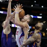 Los Angeles Clippers' Blake Griffin, center, is defended by Phoenix Suns' Alex Len, left, of Ukraine, and Markieff Morris during the first half of an NBA basketball game Monday, Dec. 8, 2014, in Los Angeles. (AP Photo/Jae C. Hong)