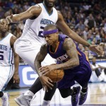 Phoenix Suns' Isaiah Thomas, bottom, falls after being fouled by Charlotte Hornets' Al Jefferson during the second half of an NBA basketball game in Charlotte, N.C., Wednesday, Dec. 17, 2014. The Suns won 111-106. (AP Photo/Chuck Burton)