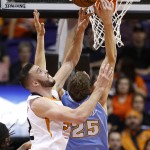 Denver Nuggets' Timofey Mozgov (25), of Russia, battles Phoenix Suns' Miles Plumlee, left, for a rebound during the first half of an NBA basketball game Wednesday, Nov. 26, 2014, in Phoenix. (AP Photo/Ross D. Franklin)
