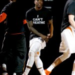 Phoenix Suns' Eric Bledsoe stands on the court during announcements prior to an NBA basketball game against the Milwaukee Bucks, Monday, Dec. 15, 2014, in Phoenix. The Phoenix Suns took the court for pregame warmups Monday night wearing T-shirts bearing the protest slogan "I Can't Breathe." (AP Photo/Matt York)