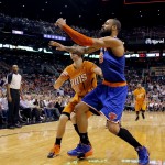  New York Knicks' Tyson Chandler, right, hits Phoenix Suns' Goran Dragic, of Slovenia, in the face while chasing a lose ball during the first half of an NBA basketball game, Friday, March 28, 2014, in Phoenix. Dragic left the game after being hit. (AP Photo/Matt York)