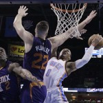 Oklahoma City Thunder guard Russell Westbrook (0) goes up for a shot as Phoenix Suns center Miles Plumlee (22) defends in the first quarter of an NBA basketball game in Oklahoma City, Sunday, Dec. 14, 2014. Suns guard Eric Bledsoe (2) is at left. (AP Photo/Sue Ogrocki)