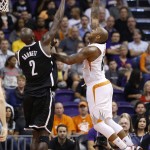 Phoenix Suns' P.J. Tucker, right, gets a shot off over Brooklyn Nets' Kevin Garnett (2) during the first half of an NBA basketball game Wednesday, Nov. 12, 2014, in Phoenix. (AP Photo/Ross D. Franklin)