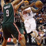 Phoenix Suns' Isaiah Thomas (3) drives as Milwaukee Bucks' Jared Dudley defends during the second half of an NBA basketball game, Monday, Dec. 15, 2014, in Phoenix. The Bucks won 96-94. (AP Photo/Matt York)