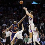 Los Angeles Clippers' Blake Griffin, right, shoots a buzzer-beating three-point basket over Phoenix Suns' P.J. Tucker in overtime of an NBA basketball game Monday, Dec. 8, 2014, in Los Angeles. The Clippers won 121-120 in overtime. (AP Photo/Jae C. Hong)