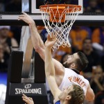 Dallas Mavericks' Dirk Nowitzki, front, of Germany, battles Phoenix Suns' Miles Plumlee for a rebound during the first half of an NBA basketball game Tuesday, Dec. 23, 2014, in Phoenix. (AP Photo/Ross D. Franklin)
