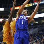 Philadelphia 76ers' Michael Carter-Williams (1) gets past Phoenix Suns' Eric Bledsoe, left, and P.J. Tucker to score during the first half of an NBA basketball game Friday, Jan. 2, 2015, in Phoenix. (AP Photo/Ross D. Franklin)
