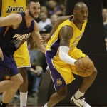 Los Angeles Lakers' Kobe Bryant, center, steals a ball from Phoenix Suns' Miles Plumlee, left, during the first half of a preseason NBA basketball game on Tuesday, Oct. 21, 2014, in Anaheim, Calif. (AP Photo/Jae C. Hong)