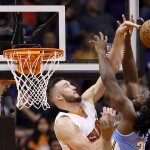 Phoenix Suns' Miles Plumlee, left, blocks the shot of Denver Nuggets' Kenneth Faried, right, during the second half of an NBA basketball game, Wednesday, Nov. 26, 2014, in Phoenix. The Suns' Plumlee was called for a foul on the play, but the Suns defeated the Nuggets 120-112. (AP Photo/Ross D. Franklin)